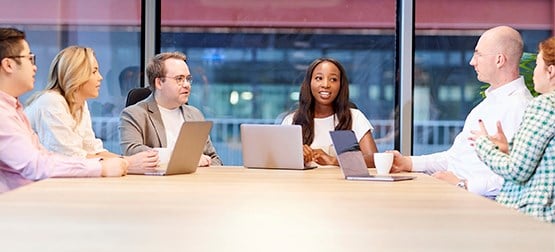 People sat at a table with laptops